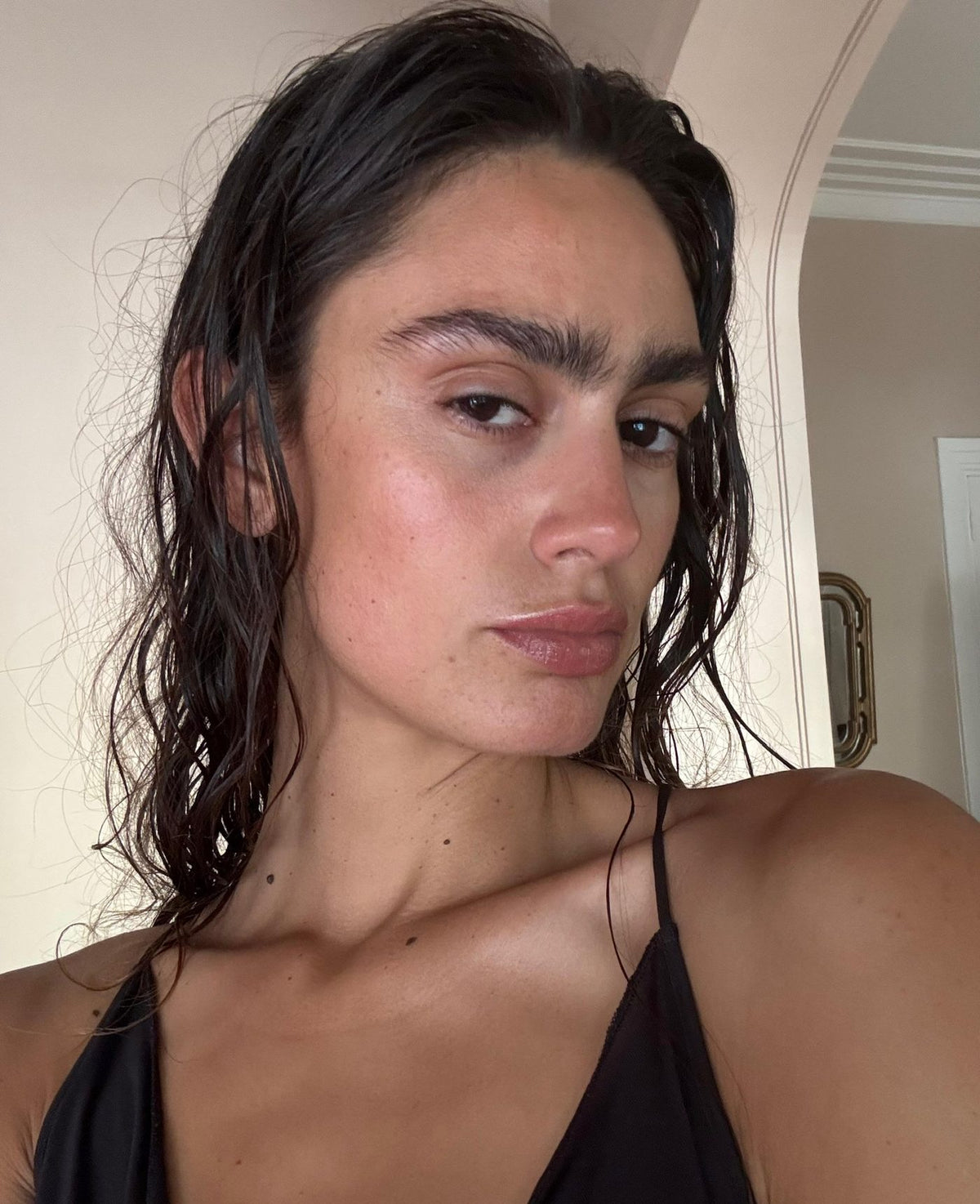 Close-up portrait of a woman with wet hair and dewy skin