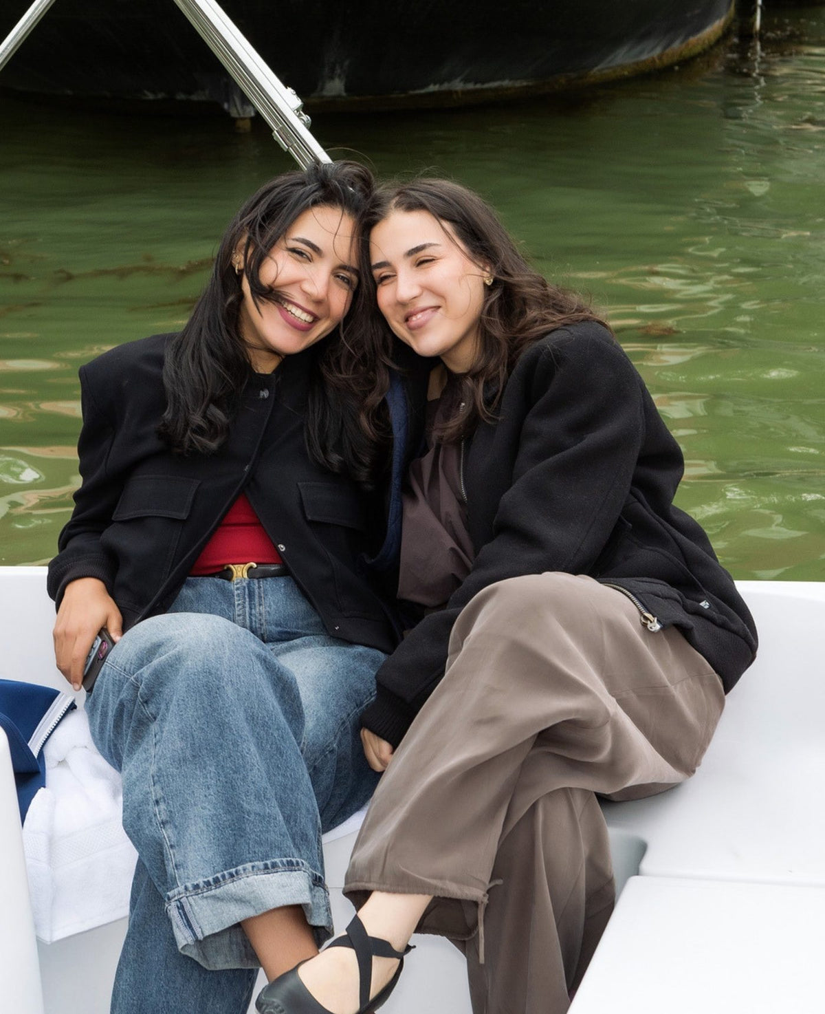Two friends sitting close together on a boat on a canal
